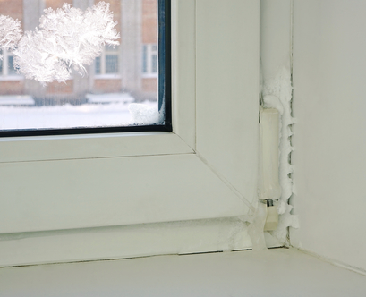 damaged window frame with condensation occuring between a double pane window.